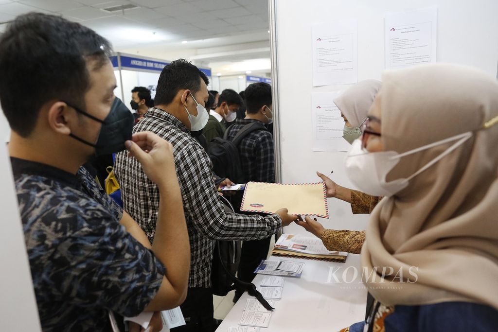Pencari kerja menyerahkan lamaran di salah satu stan<i> </i>peserta Jakarta Job Fair di mal Seasons City, Jakarta, Rabu (2/11/2022). Di tengah kondisi pandemi Covid-19 yang belum berakhir, penggunaan masker di tempat umum, seperti di ajang Jakarta Job Fair, melindungi orang dari penularan Covid-19  