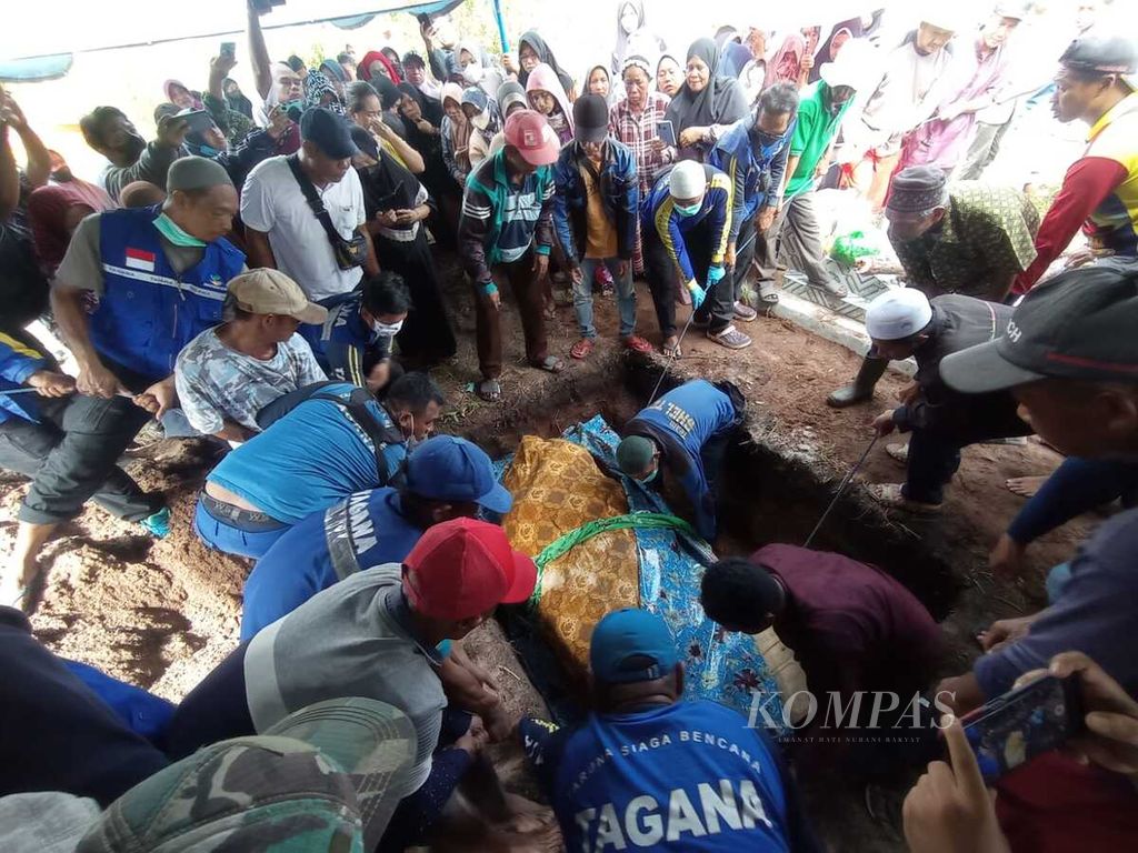 Keluarga dan petugas serta beberapa lembaga masyarakat membantu proses pemakaman Titi Wati (42), penderita obesitas di Kota Palangkaraya, Kalimantan Tengah, Senin (30/1/2023). Titi Wati meninggal dalam keadaan berat badan 209 kilogram.