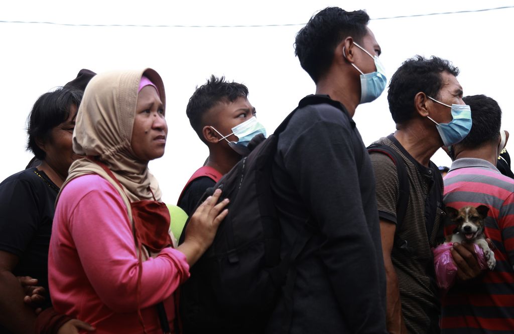 Warga mengantre saat evakuasi menggunakan KRI Kakap-811 di Pelabuhan Tagulandang, Kabupaten Kepulauan Sitaro, Sulawesi Utara, Rabu (1/5/2024).