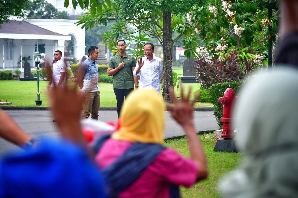 Warga yang menerima bantuan kebutuhan pokok melambaikan tangan dan menyerukan ucapan terima kasih kepada Presiden Joko Widodo di Gedung Agung Yogyakarta, Jumat (24/5/2024).