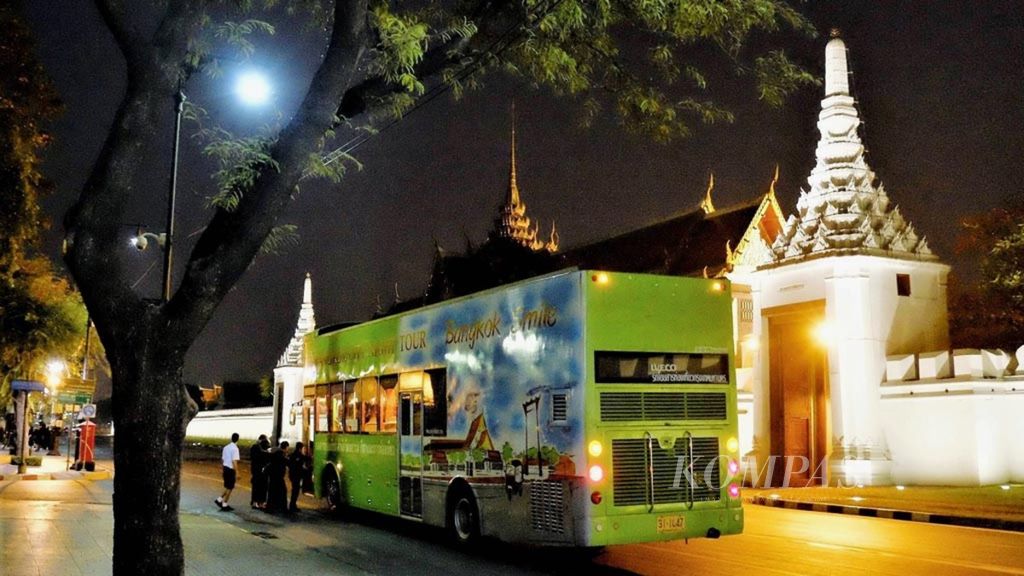 Sejumlah warga siap menaiki bis wisata malam di depan kompleks Istana Kerajaan di Bangkok, Thailand, Sabtu (18/2/2017).  