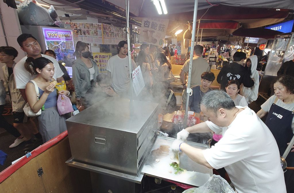 Warga menikmati kuliner jajanan di pasar malam di Taipei, Taiwan, Minggu (31/3/2024). 