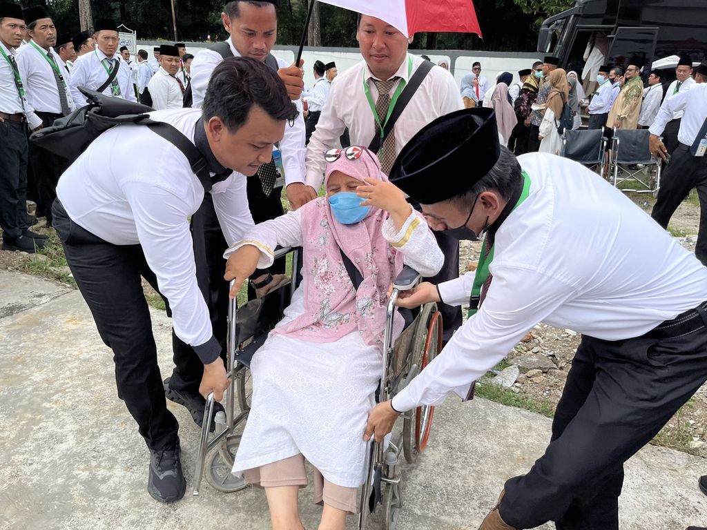 Petugas haji membantu seorang pemeran jemaah haji disabilitas yang baru tiba di Mina saat simulasi layanan petugas dalam acara bimbingan teknis Petugas Penyelenggara Ibadah Haji Arab Saudi di Asrama Haji Pondokgede, Jakarta, Selasa (26/3/2024). 