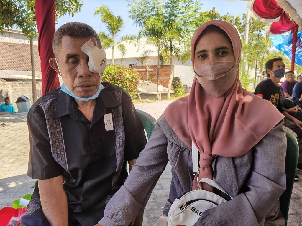 Eli Ismayani (kanan) mendampingi ayahnya, Wildan, yang baru selesai operasi katarak gratis yang diselenggarakan Yayasan Dana Kemanusiaan Kompas bersama Kementerian Sosial di UPTD RSUD Lombok Timur, Labuan Haji, Selong, NTB, Minggu (31/7/2022). Operasi katarak gratis itu didanai bantuan pembaca harian <i>Kompas</i>.