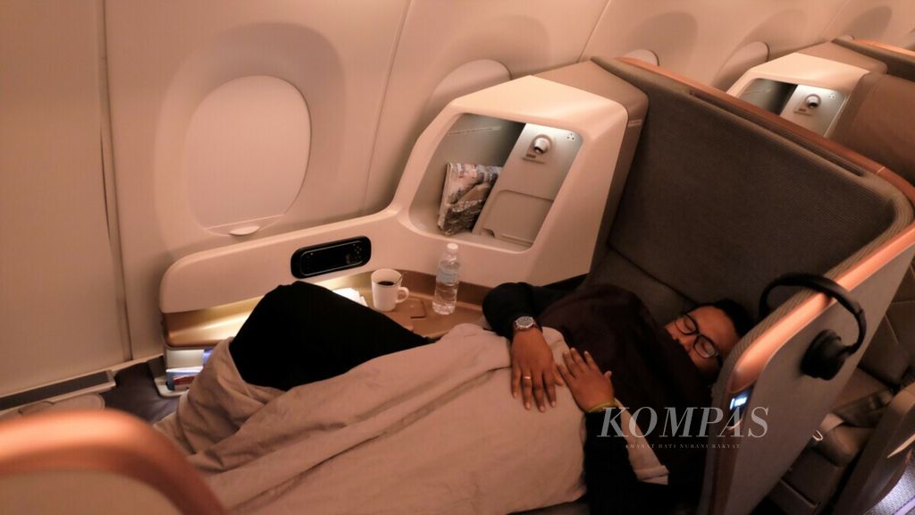 Penumpang tidur di kursi kelas bisnis Singapore Airlines rute Singapura-Düsseldorf.