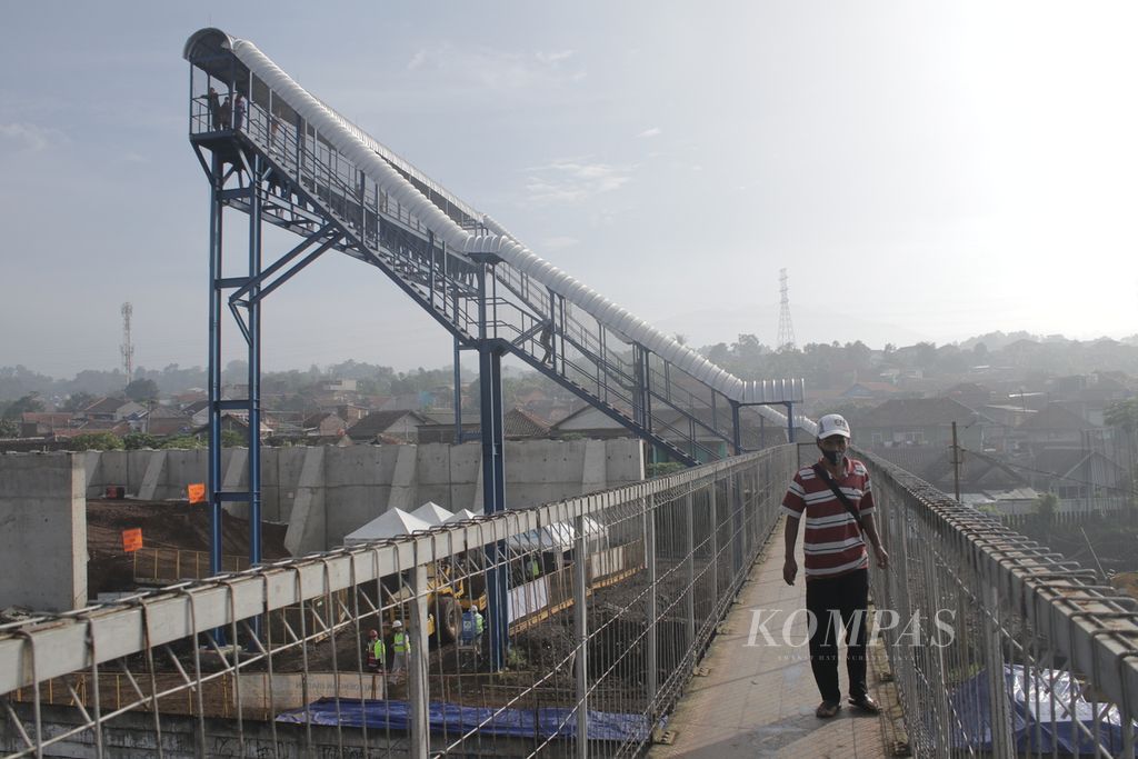 Seorang warga melintasi jembatan penyeberangan di stasiun konektivitas Kereta Cepat Jakarta-Bandung, Stasiun Padalarang, Kabupaten Bandung Barat, Jawa Barat, Senin (12/4/2021). Jembatan penyeberangan ini memiliki tinggi 15 meter.