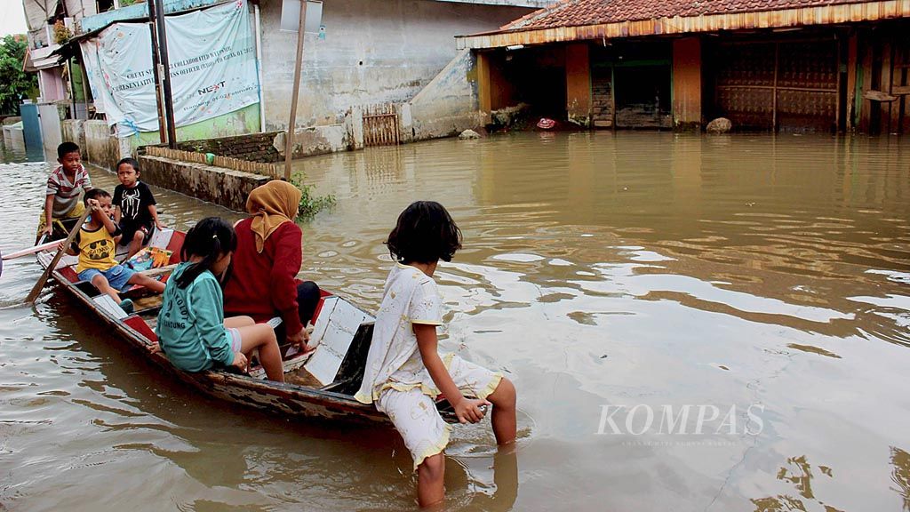 Warga menggunakan perahu melintasi banjir di Dayeuhkolot, Kabupaten Bandung, Jawa Barat, Rabu (8/11). Hujan lebat selama lima jam pada Selasa malam membuat lebih dari 1.000 rumah warga di Dayeuhkolot, Baleendah, dan Bojongsoang terendam banjir hingga ketinggian 1,2 meter.