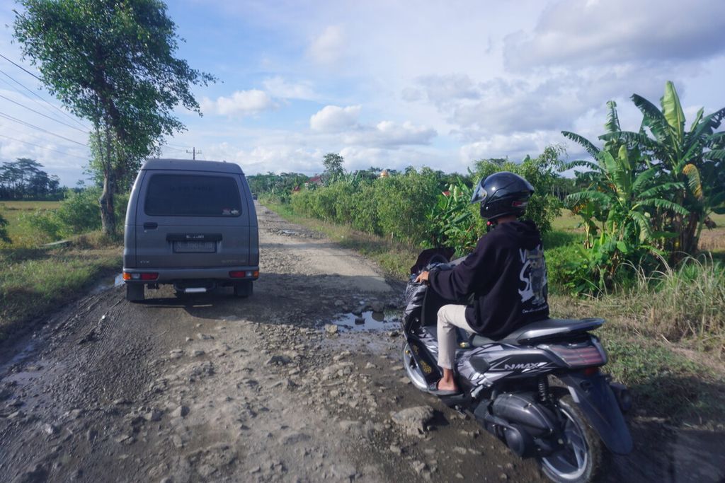 Pengendara melintasi jalan yang rusak parah di Ujungmanik, Kecamatan Kawunganten, Kabupaten Cilacap, Jawa Tengah, Sabtu (15/4/2023).