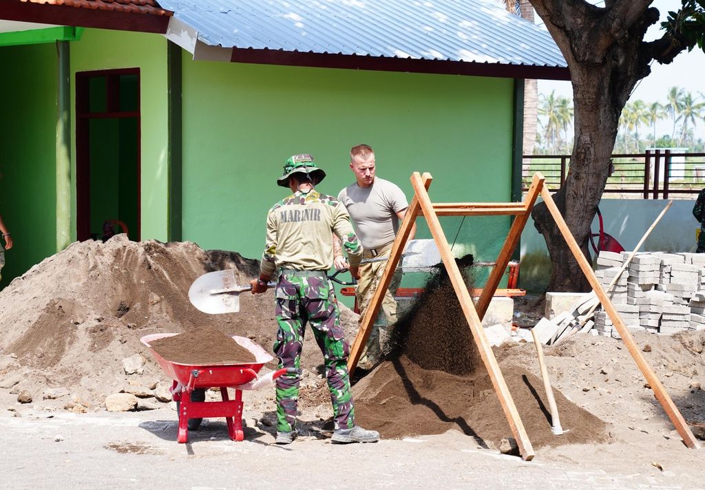 Anggota TNI bersama prajurit dari Amerika Serikat dan Kanada bekerja sama memperbaiki gedung SD di Situbondo, Jawa Timur, baru-baru ini. Kerja sama ini untuk menjalin persahabatan dan saling percaya. 