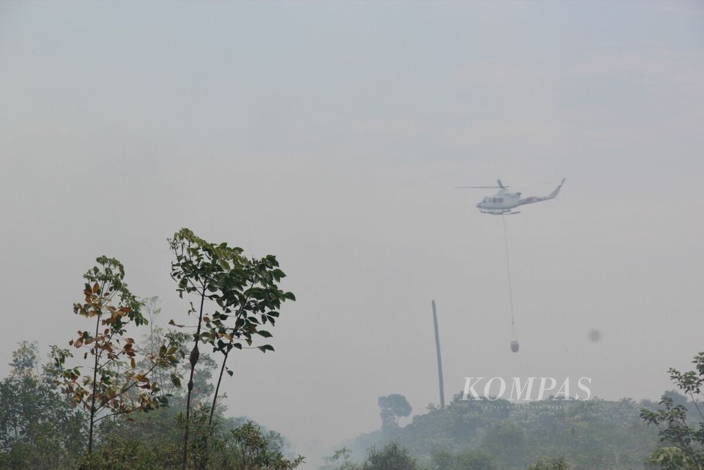 Helikopter Kementerian Lingkungan Hidup dan Kehutanan membawa <i>bucket air</i> sebanyak 1.000 liter untuk dituangkan ke lokasi kebakaran di Kelurahan Terkul, pada Kamis (28/2/2019).