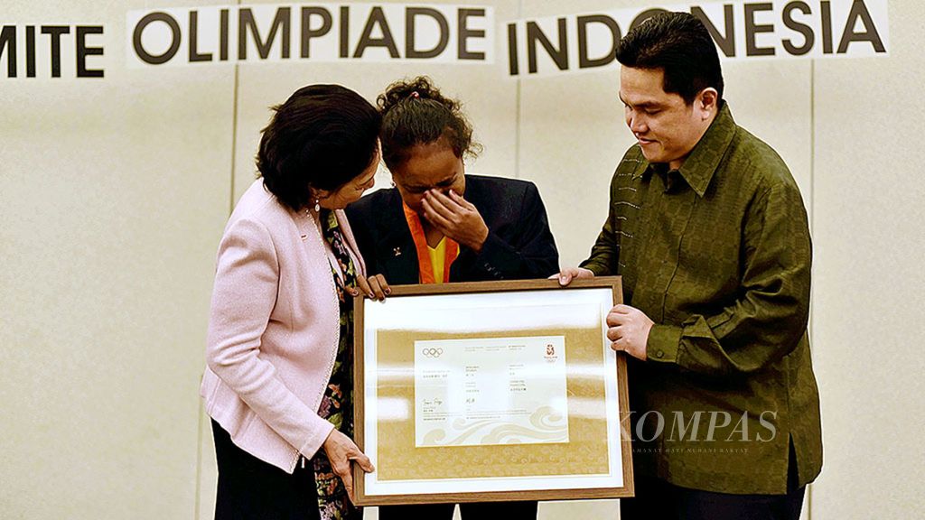 Former national weightlifter Lisa Rumbewas (center) was moved when she received a certificate of appreciation as the winner of the bronze medal for the 53-kilogram weightlifting event at the Beijing 2008 Olympics from senior member of the International Olympic Committee, Rita Soebowo (left), and Chairman of the Indonesian Olympic Committee, Erick Thohir (right), in Jakarta.
