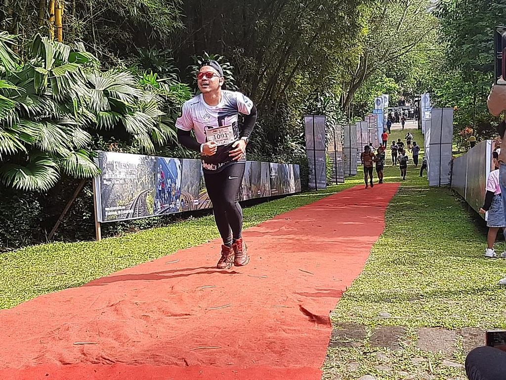 Seorang pelari MesaStila Rails To Trails 16K berlari menuju garis finis di MesaStila Resort and Spa, Minggu (13/3/2022).