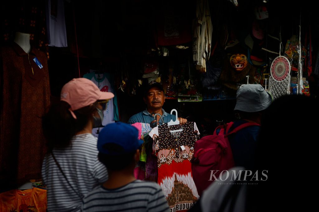 Pedagang menawarkan pakaian kepada wisatwan seusai berkunjung dari Candi Borobudur, di Kabupaten Magelang, Jawa Tengah, Jumat (3/6/2022). Pelonggaran pembatasan sosial dan berjalannya kembali industri wisata turut menggerakkan perekonomian warga.