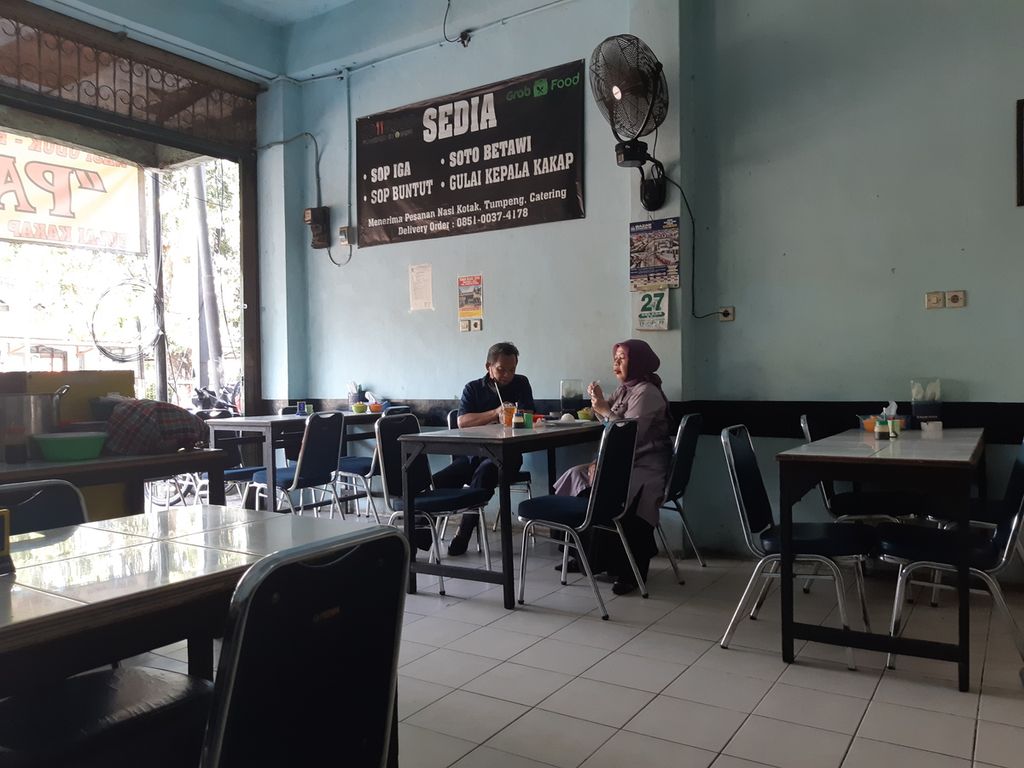 Dua pelanggan sedang makan di tempat di salah satu warung makan di Pasar Proyek, Bekasi Jaya, Kota Bekasi, pada Selasa (27/7/2021) siang. Pelaku usaha enggan menerapkan aturan makan di tempat selama 20 menit karena tak ingin mengganggu kenyamanan pelanggan.