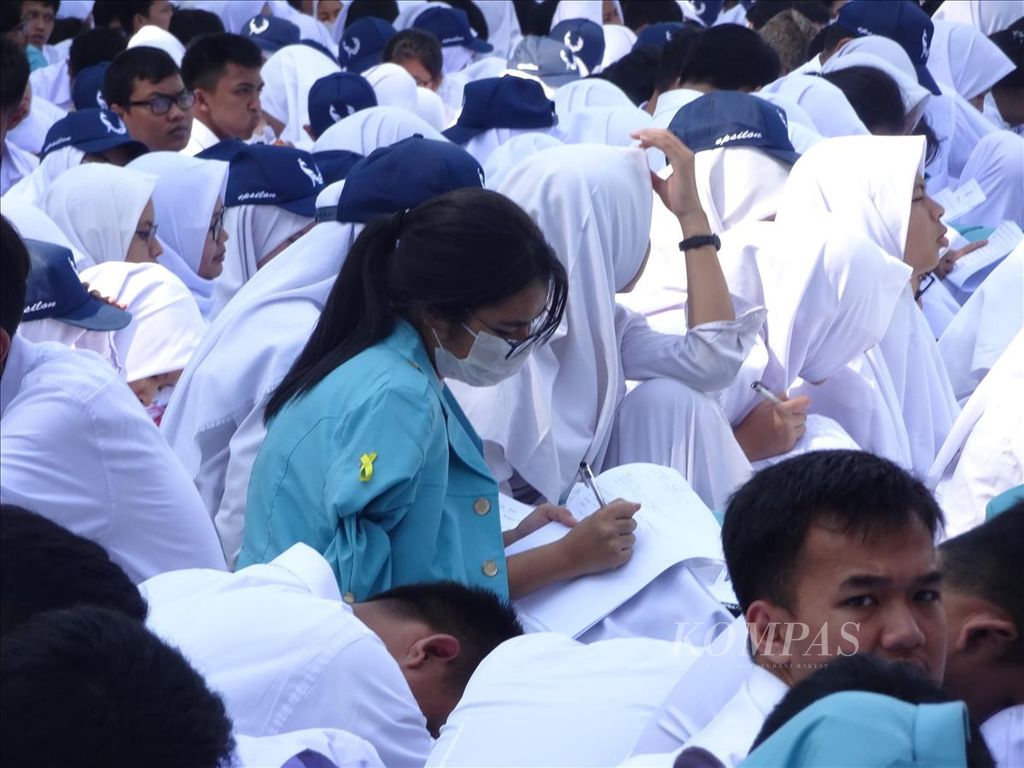 Mahasiswa baru Universitas Sebelas Maret membuat catatan saat mengikuti kuliah umum Menteri Pertahanan Ryamizard Ryacudu di halaman Rektorat UNS di Solo, Jawa Tengah, Selasa (13/8/2019).