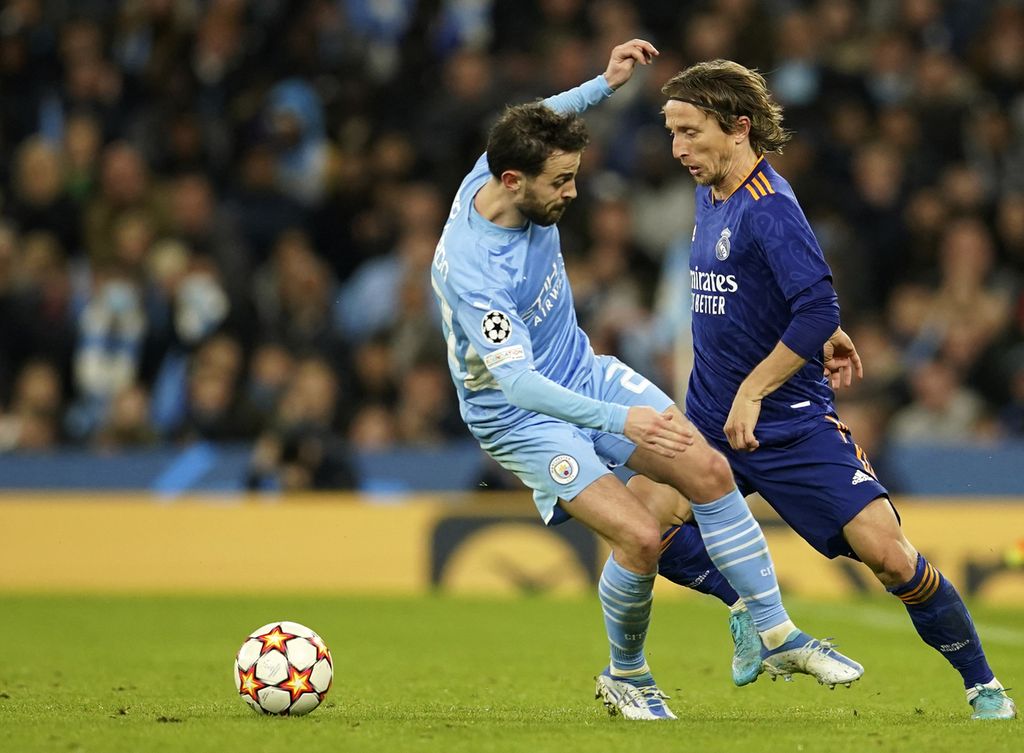 Real Madrid player Luka Modric (right) and Manchester City player Bernardo Silva duel for the ball in the first round of the European Champions League semi-finals between Manchester City and Real Madrid at Etihad Stadium, Manchester, England on Wednesday (27/4 /2022). Manchester City won 4-3.
