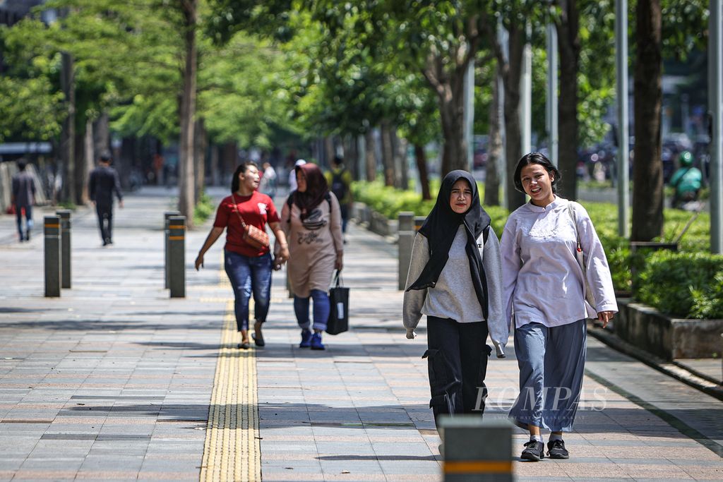 Warga berjalan di trotoar di Jalan Jenderal Sudirman, Jakarta, Jumat (1/3/2024). Fasilitas trotoar yang memadai turut mendorong minat warga untuk berjalan kaki dan menggunakan transportasi umum. 
