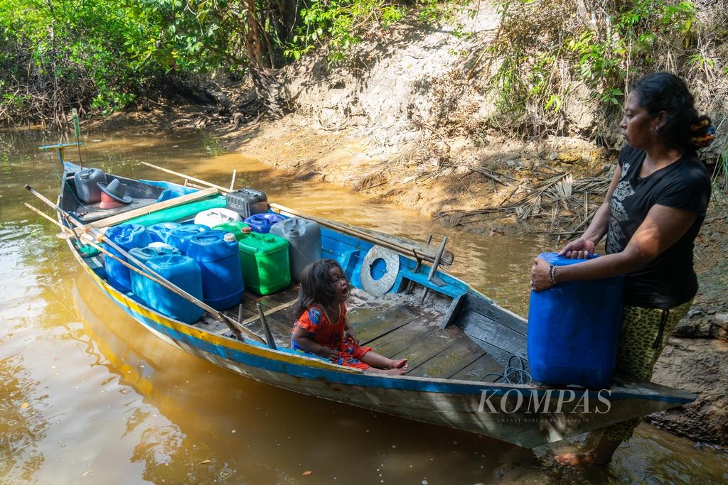 Seorang warga suku Laut, Ida (34), mengambil air bersama anaknya di Sungai Pinang, Desa Tajur Biru, Kecamatan Temiang Pesisir, Kabupaten Lingga, Kepulauan Riau, Minggu (17/7/2022). 