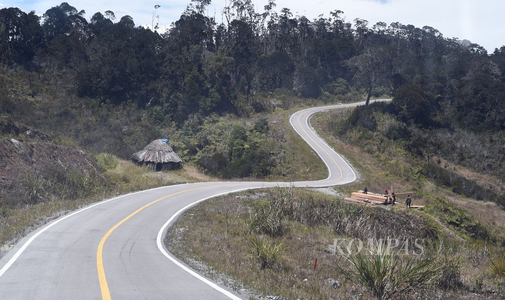Warga menyusun kayu hasil tebangan hutan di pinggir Jalan Trans Papua, Kabupaten Jayawijaya, Papua, Jumat (12/11/2021). Dari data Kementerian Pekerjaan Umum dan Perumahan Rakyat (PUPR), di Provinsi Papua total Jalan Trans-Papua sepanjang 2.350,72 km. Hingga akhir 2021, total jalan dengan perkerasan aspal mencapai 977,47 km dan jalan agregat padat tahan cuaca sepanjang 1.363,16 km. Khusus untuk Jalan Trans Papua Segmen V yang melintasi Wamena-Habema-Kenyam-Mamugu yang direncanakan sepanjang 271,60 km, panjang jalan yang telah diaspal 54,4 km dan jalan agregat padat, 217,15 km. Kompas/Bahana Patria Gupta (BAH)