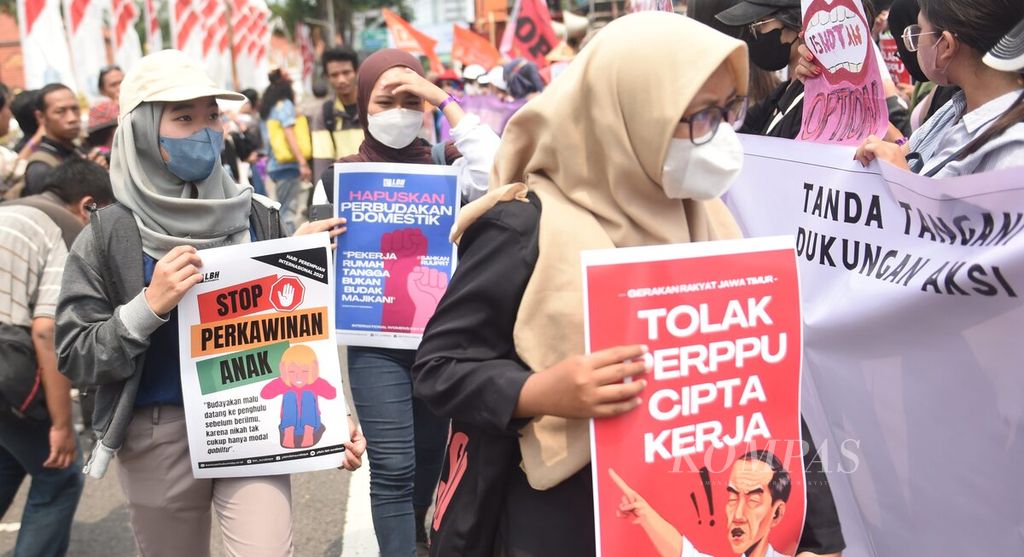 Dengan menggunakan sebagai badan jalan, aktivis yang tergabung bersama Aliansi Gerak (Gerakan Rakyat) berunjuk rasa memperingati Hari Perempuan Internasional di Jalan Gubernur Suryo, Surabaya, Jawa Timur, Rabu (8/3/2023). 