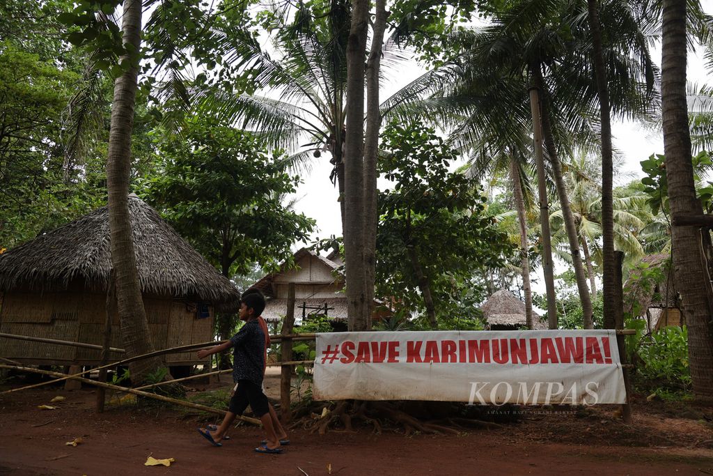 Spanduk dukungan terhadap gerakan melawan praktik tambak udang di kawasan konservasi Karimunjawa dipasang di sebuah penginapan di Desa Kemujan, Karimunjawa, Jepara, Jawa Tengah, Kamis (18/4/2024).