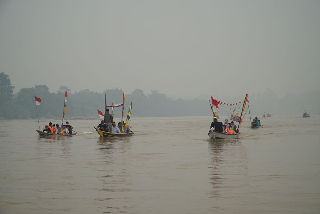 Sejumlah perahu dari Karnaval Arung Pamalayu melintasi Sungai Batanghari, Dharmasraya, Sumatera Barat, Senin, 23 September 2019. 