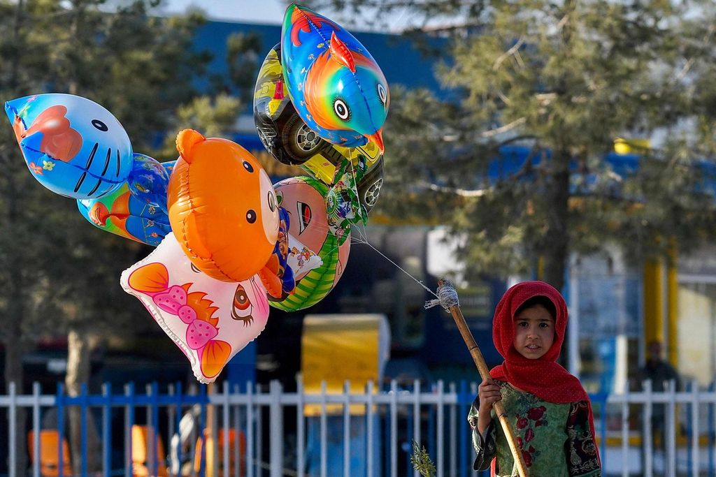 Seorang anak menjual balon-balon mainan di Kabul, Afghanistan, 30 Maret 2022. 