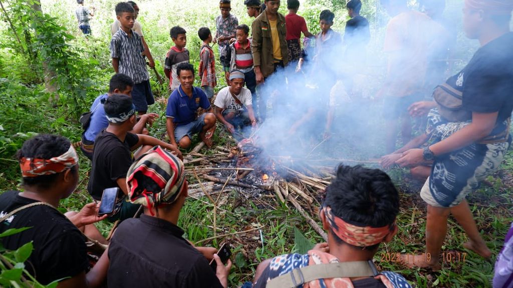 Tetua adat Sumba membakar sesajian berupa ayam jantan untuk dipersembahkan kepada para leluhur Marapu untuk mengawal hutan, air, pohon-pohon, dan tanah ulayat di wilayah Sumba, Senin (21/11/2022).