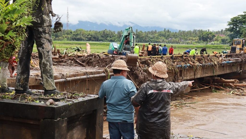 Cuaca ekstrem dengan hujan lebat mengakibatkan bencana banjir bandang di Jembrana, Bali. Dokumentasi Pemkab Jembrana menampilkan kondisi jembatan penghubung di Mendoyo, Jembrana, Senin (17/10/2022), yang tertutupi material sampah, yang dihanyutkan air bah. 