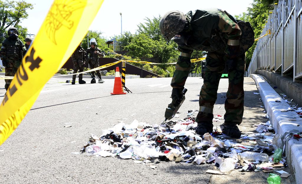 Tentara Korea Selatan yang mengenakan alat pelindung diri memeriksa sampah dari balon yang diduga dikirim oleh Korea Utara, di Incheon, Korea Selatan, Minggu (2/6/2024). 