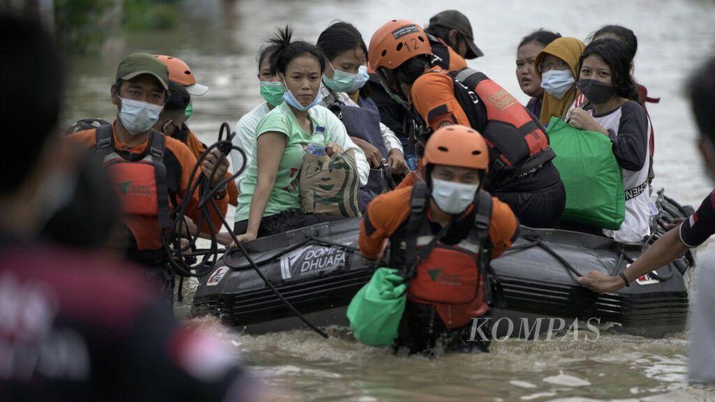 Evakuasi warga menggunakan perahu karet di Perumahan Pondok Gede Permai di Jatiasih, Kota Bekasi, Jawa Barat, Jumat (19/2/2021) akibat luapan banjir Sungai Cileungsi dan Sungai Cikeas. Banjir diperparah dengan jebolnya tanggul Sungai Bekasi dan merendam kawasan ini hingga ketinggian dua meter. Puluhan warga sementara mengungsi di gudang logistik BNPB. Badan Penanggulangan Bencana Daerah (BPBD) Kota Bekasi mencatat hingga Jumat siang (19/2/2021) ada 40 titik genangan yang tersebar di delapan kecamatan di Kota Bekasi.