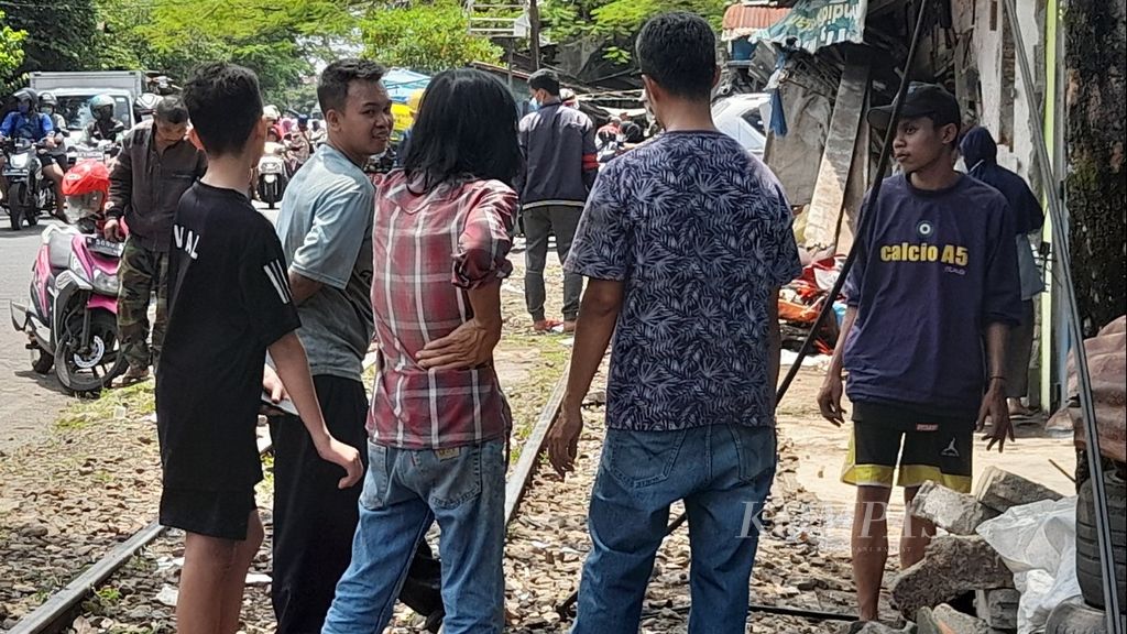Warga masih berkerumun di lokasi bekas kecelakaan antara kereta bermuatan bahan bakar dan minibus di Jalan Halmahera di Kelurahan Ciptomulyo, Kecamatan Sukun, Kota Malang, Jawa Timur, Minggu (17/4/2022).