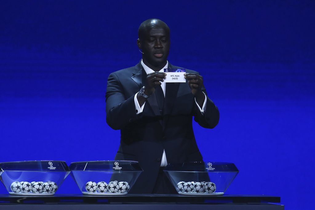 Mantan pemain sepak bola asal Pantai Gading, Yaya Toure, menunjukkan kertas bertuliskan klub Ajax saat acara undian fase grup Liga Champions 2022-2023 di Istanbul, Turki, Jumat (26/8/2022) dini hari WIB. 