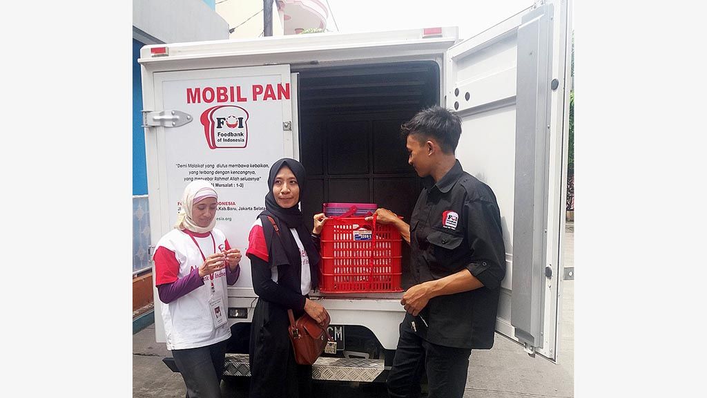 Karyawan Foodbank of Indonesia memasukkan boks makanan usai menyalurkan makanan di Jakarta Utara.