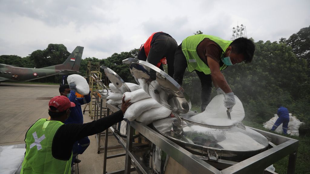 Pekerja mengisi garam semai ke konsol penampung sebelum dimasukkan ke pesawat CN 295 Skuadron 2 TNI AU di Lanud Halim Perdanakusuma untuk operasi teknologi modifikasi cuaca di langit kawasan Selat Sunda, Jumat (3/1/2020). 