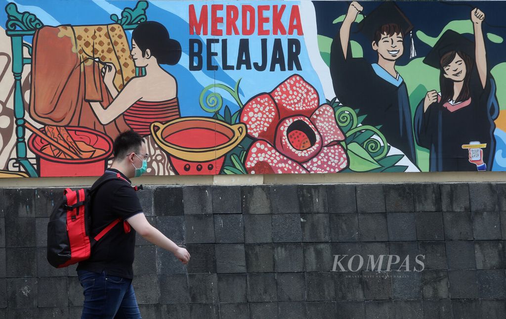 Warga melintas di depan mural tentang Merdeka Belajar di kawasan Sudirman, Jakarta, Selasa (9/5/2023).