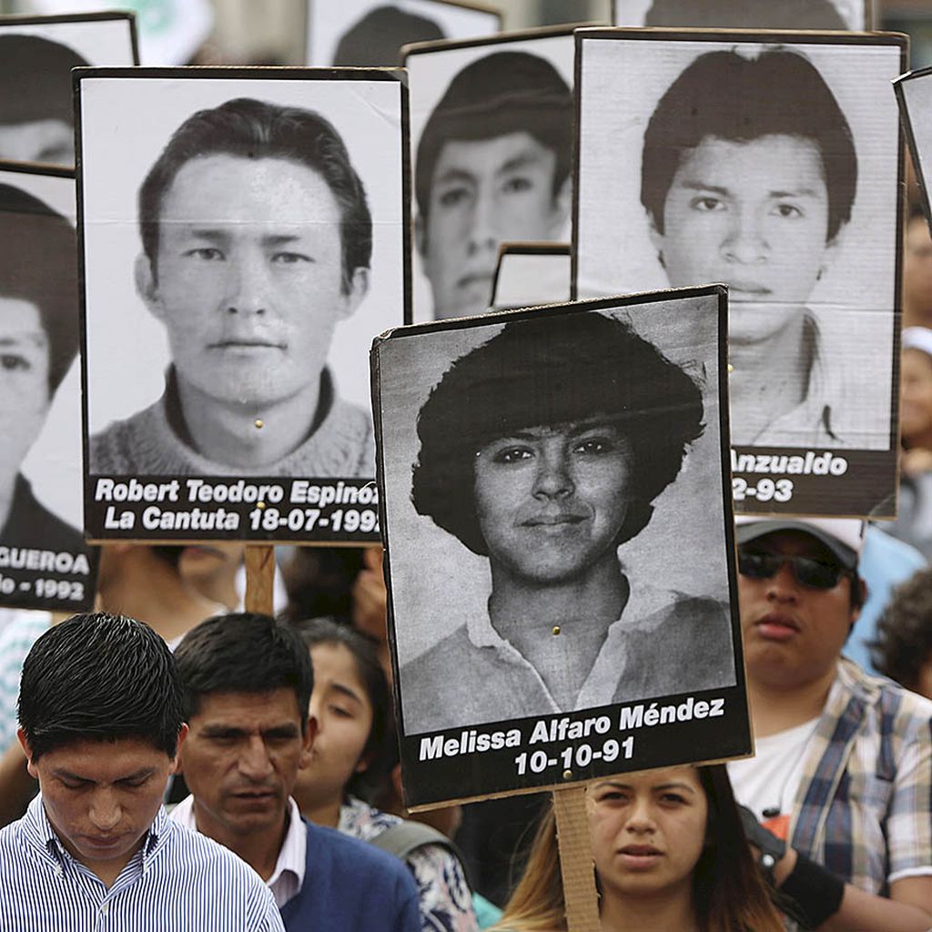 Pengunjuk rasa, Senin (25/12), di Lima, Peru, membawa foto orang-orang yang hilang selama Alberto Fujimori menjabat sebagai presiden. Warga menentang keputusan Presiden Peru Pedro Pablo Kuczynski yang memberikan pengampunan kepada Fujimori. 