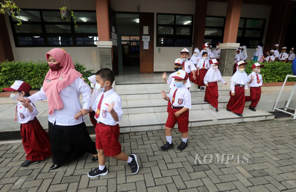 Guru mengarahkan siswa baru kelas 1 sekolah dasar pada hari pertama sekolah tahun ajaran baru 2022/2023 di SDN 11 Pondok Bambu, Jakarta, Senin (11/7/2022). 