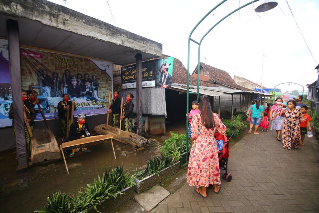 Pengunjung Pasar Kampoeng Osing menyaksikan pertunjukan kesenian musik gedogan di Pasar Kampoeng Osing, Desa Kemiren, Kecamatan Glagah, Banyuwangi, Jawa Timur, Sabtu (17/4/2021). Desa Kemiren merupakan salah satu dari 16 Desa Wisata Berkelanjutan yang dipilih oleh Kementerian Pariwisata dan Ekonomi Kreatif.