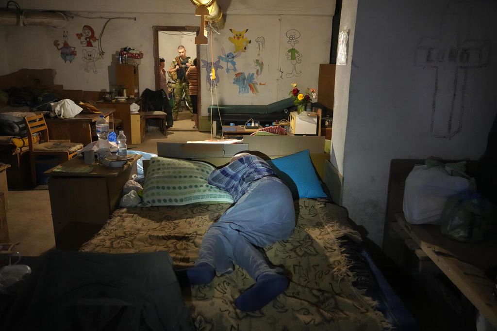 Seorang pria berbaring di atas tempat tidur saat berlindung dari serangan Rusia di ruang bawah tanah rumahnya di Lysychansk, wilayah Luhansk, Ukraina, Kamis (16/6/2022). 