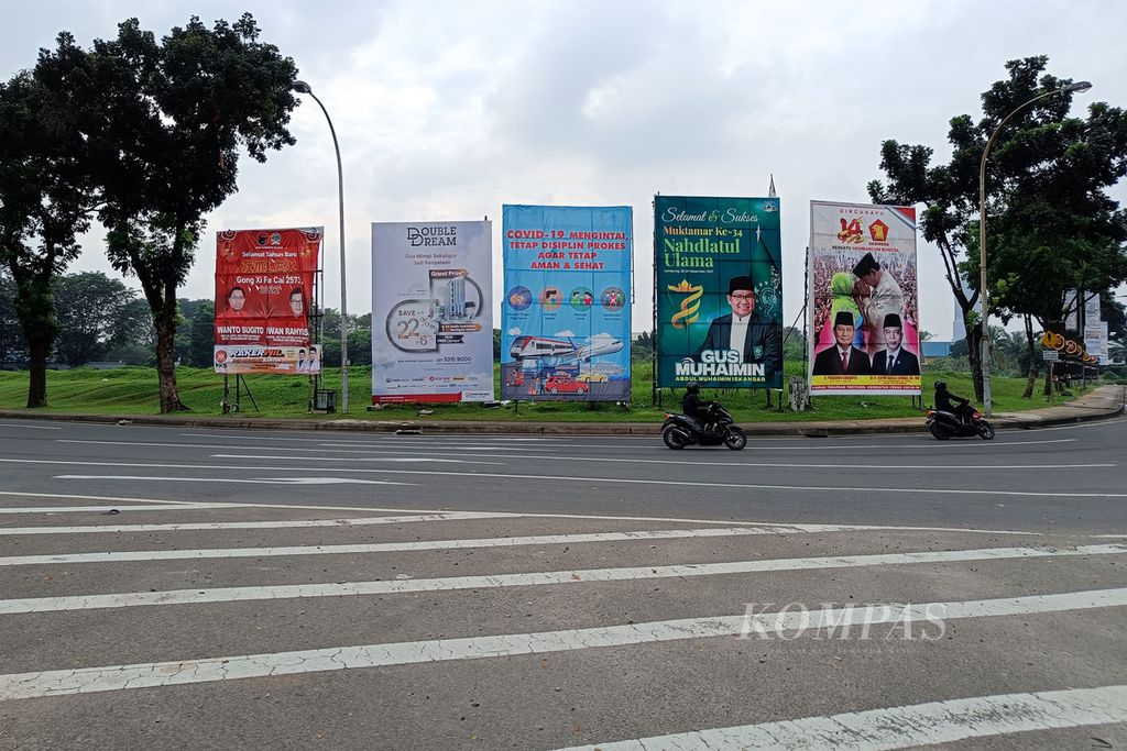 Baliho partai politik dan tokoh partai bersanding dengan iklan layanan masyarakat tentang Covid-19 dan iklan komersial di pinggir Jalan Pahlawan Seribu, Tangerang Selatan, Minggu (20/2/2022). 