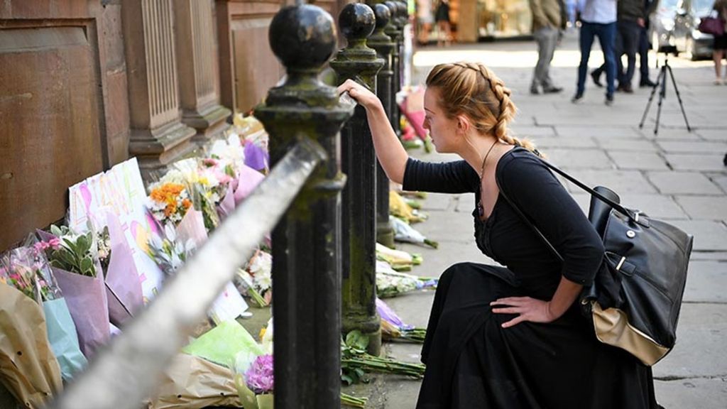 Warga membawa bunga dan meletakkannya di St Ann Square, di Manchester, Inggris, Selasa, (23/5/2017). Sedikitnya 22 orang tewas dalam peristiwa bom bunuh diri di konser pop Ariana Grande yang banyak dikunjungi anak-anak. Insiden tersebut merupakan peristiwa teror terburuk di tanah Inggris sejak pemboman London tahun 2005.