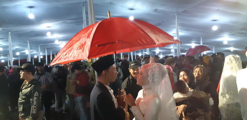 Salah satu pasangan yang baru menikah merayakan momen kebahagiaan di tengah rintik hujan di kawasan Jalan MH Thamrin, Jakarta, Senin (31/12/2018) malam.