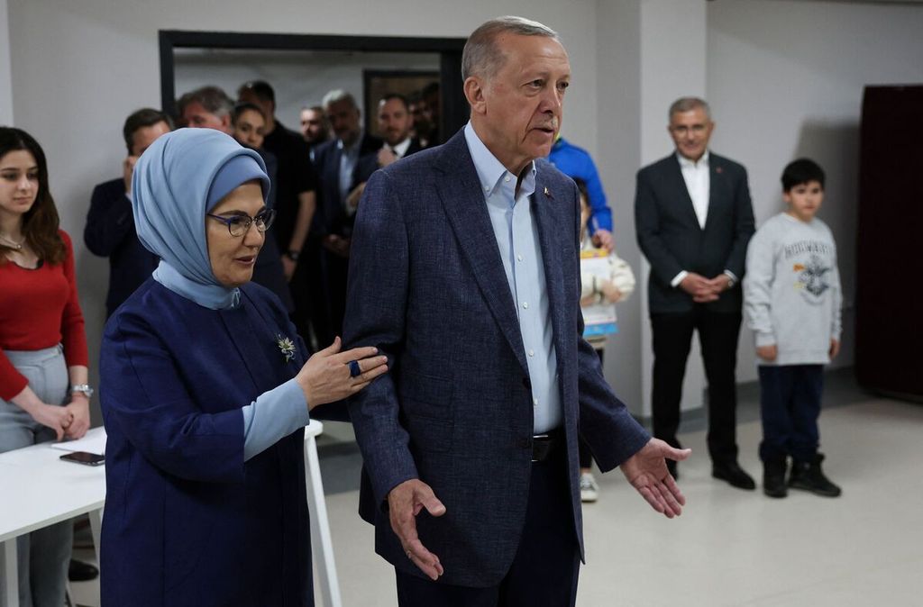 Emine Erdogan (depan, kiri) mendampingi suaminya, Presiden Turki Recep Tayyip Erdogan, di sebuah tempat pemungutan suara di Istanbul, Turki, 14 Mei 2023. 