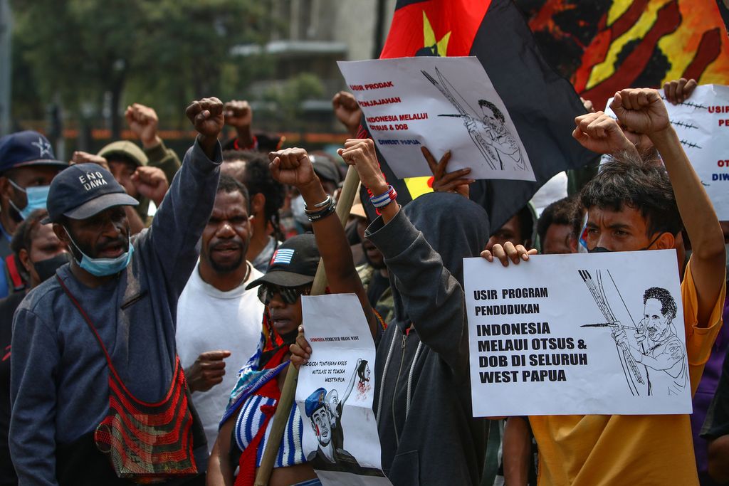 Peserta aksi mengepalkan tangan dalam aksi terkait Papua di kawasan Patung Arjuna Wijaya, Jakarta Pusat, Kamis (1/12/2022). Front Rakyat Indonesia untuk West Papua (FRI-WP), Aliansi Mahasiswa Papua (AMP), dan Asosiasi Mahasiswa Pegunungan Tengah Papua Indonesia (AMPTPI) menggelar aksi untuk memperingati 1 Desember 1961. Mereka menyuarakan sejumlah tuntutan, di antaranya penolakan terhadap otonomi khusus dan pembentukan daerah otonomi baru di Papua.
