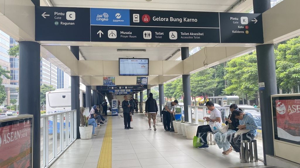 Sejumlah penumpang Transjakarta menunggu bus di Halte Gelora Bung Karno. Selasa (12/3/2024).