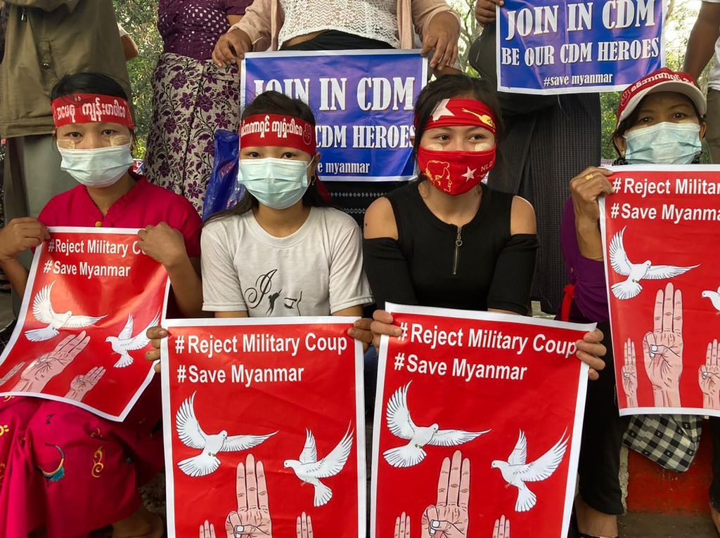 Pengunjuk rasa anti-kudeta memegang poster bertuliskan #Tolak Kudeta Militer #Save Myanmar ketika berunjuk rasa di Yangon, Myanmar Senin (22/2/2021). 