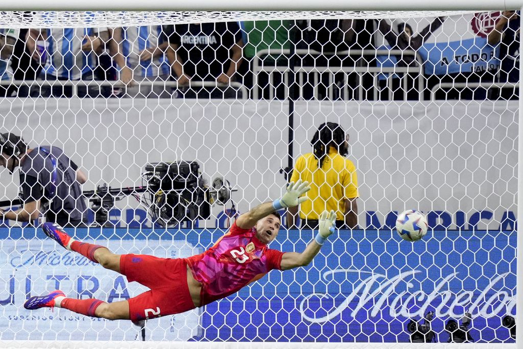 Penjaga gawang Argentina Emiliano Martinez beraksi saat adu penalti, yang dieksekusi pemain Ekuador, Angel Mena, pada pertandingan perempat final Copa America 2024 di Stadion NRG, Houston, Jumat (5/7/2024) WIB. 