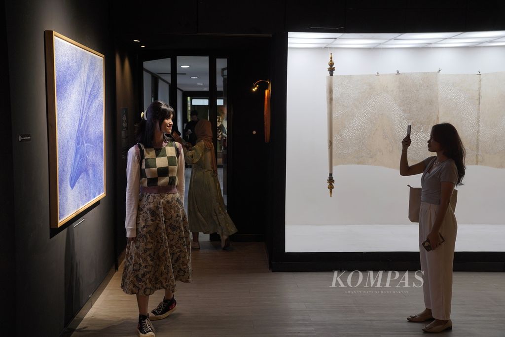 Pengunjung berfoto berlatar lukisan "Tears of the Dragon" karya Rizal Misilu (kiri) dalam pameran Enter the Dragon bagian II di Galeri Unicorn, Jakarta Art Hub, Wisma Geha, Jakarta Pusat, Rabu (7/2/2024). 