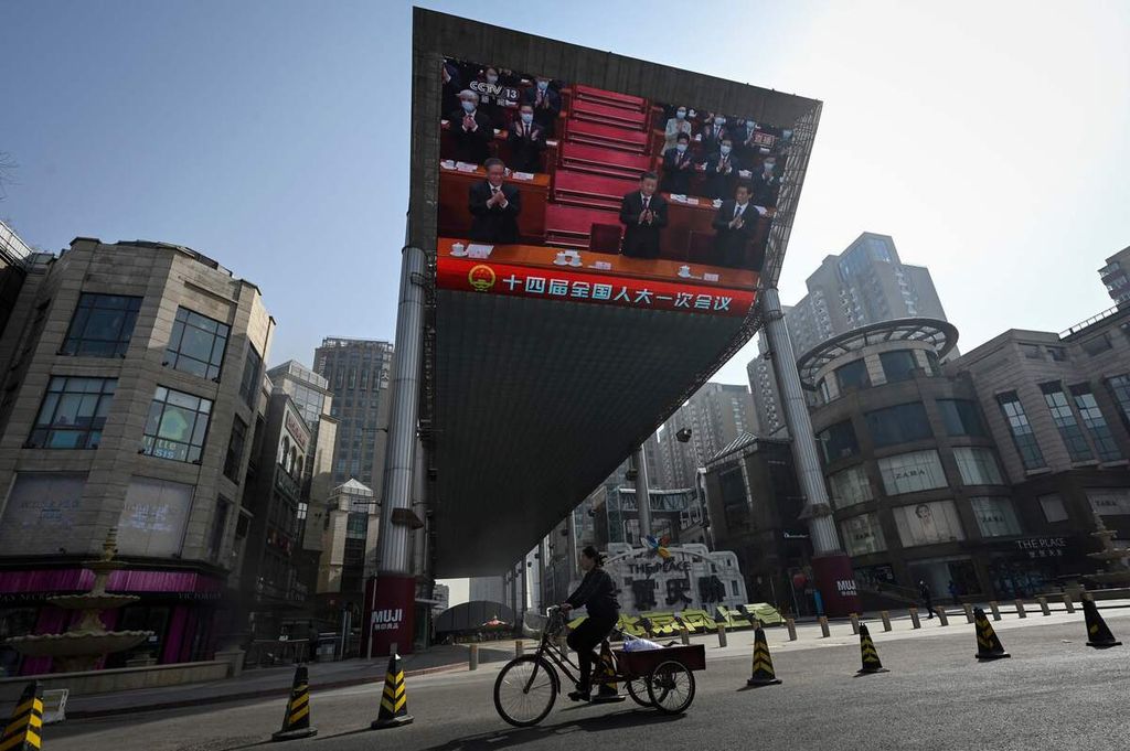 Layar raksasa menampilkan berita sidang Kongres Rakyat Nasional (NPC), seperti terlihat di salah satu ruas jalan di kota Beijing, China, Jumat (10/3/2023). 